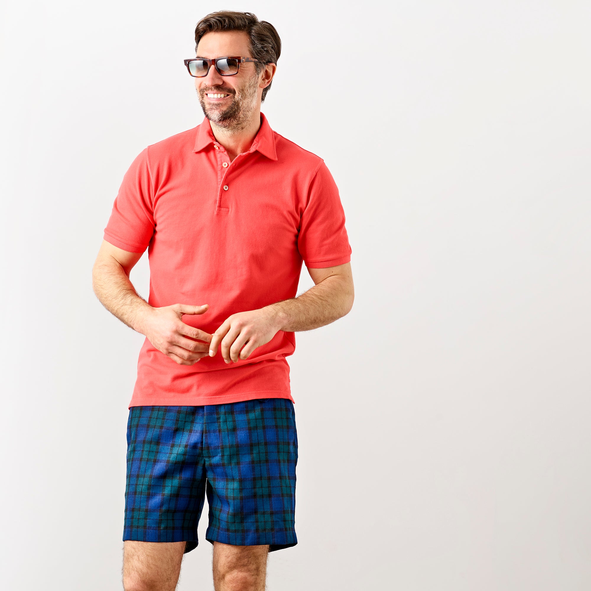 Lifestyle image of a middle aged man wearing a Fedeli Classic Short Sleeve Knitted Pique Polo Shirt Coral
